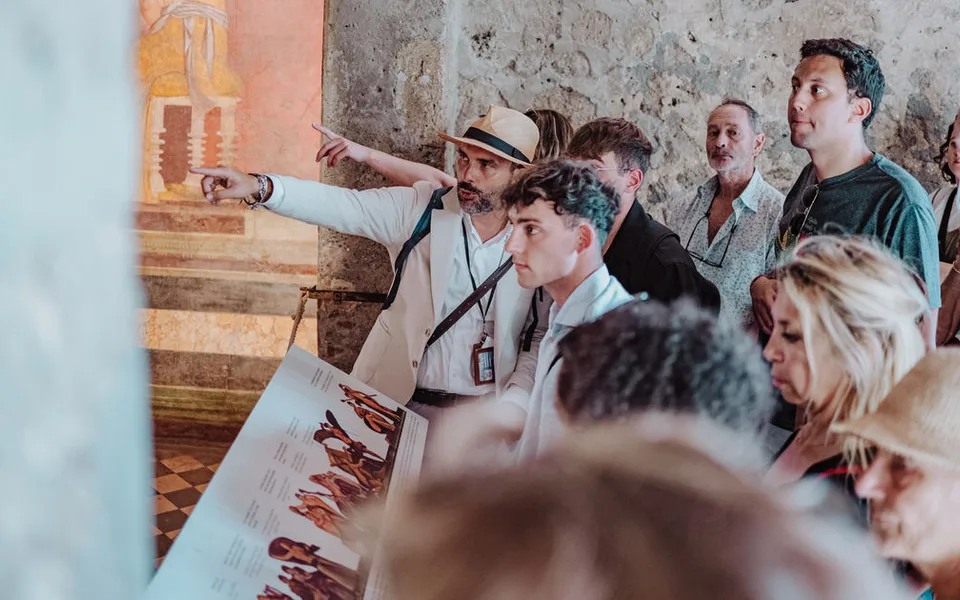 A guide leading guests through an archaeological site, featured by PhocusWire