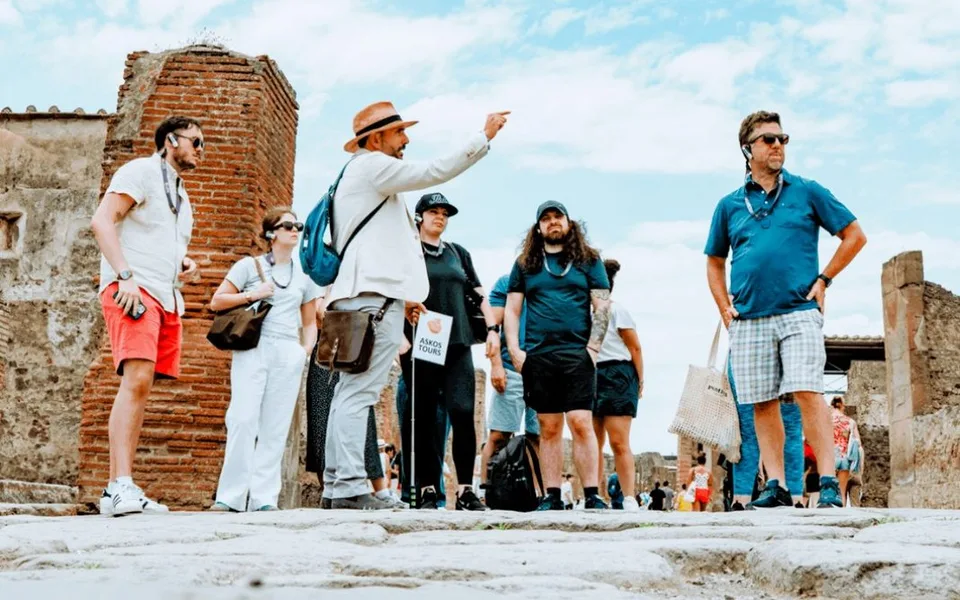 An Askos Tours guide leading guests through Pompeii, featured by TravelMole