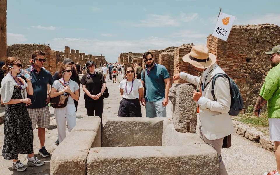 An Askos Tours guide showing guests the ancient ruins of Pompeii